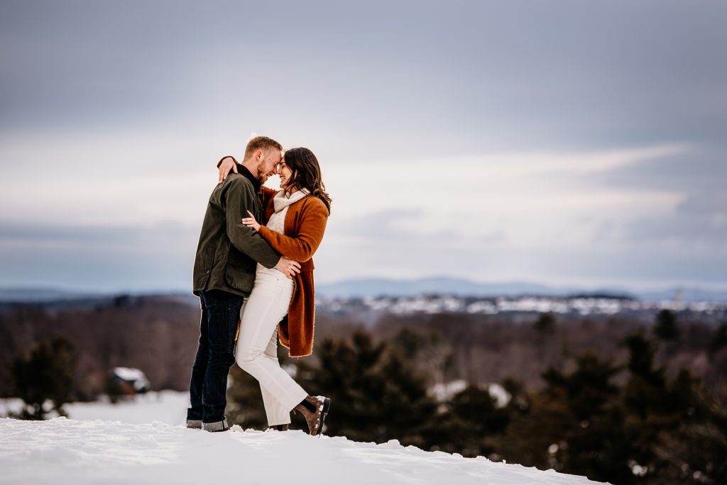 Young couple becoming engaged on a mountain in Vermont
