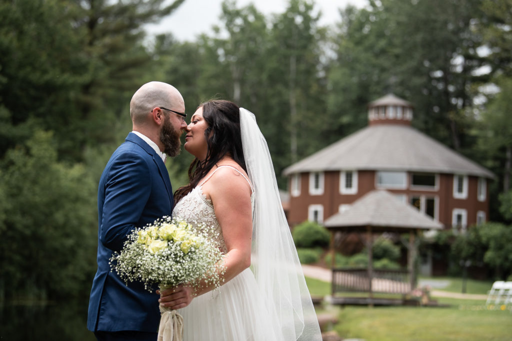 bride and groom in front of wedding barn